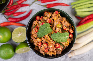 Spicy pork chops in a black cup consisting of lemons Chili and side dishes