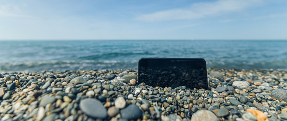 pebbly and rocky beach. smartphone. freelance coastline of the sea