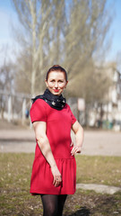 Beautiful smiling woman in red dress in a park in spring