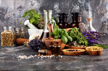 .Fresh herbs in mortar bowl from the garden and the different oils for massage and aromatherapy.