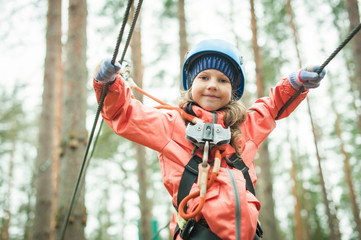 a girl walks on a tightrope to a rope park, a climbing center. Hiking in the rope park, the girls...