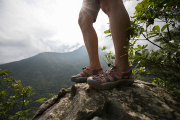 Successful hiker enjoy the view on sunrise mountain top cliff edge