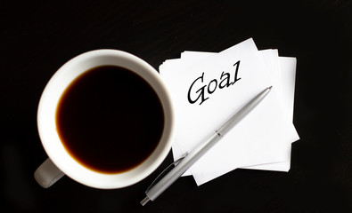 Office table with supply and coffe cup. View from above for text Goal