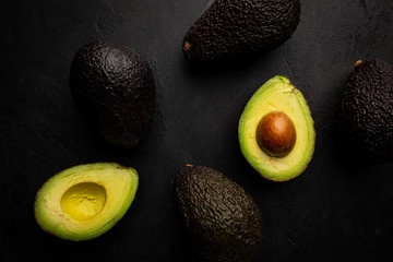 Fresh, raw avocado on a black background, top view