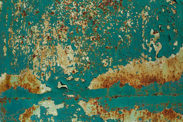 Structured surface of aged rusty wall with peeling turquoise paint