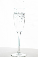 Filling up the champagne glass water  isolated on a white background