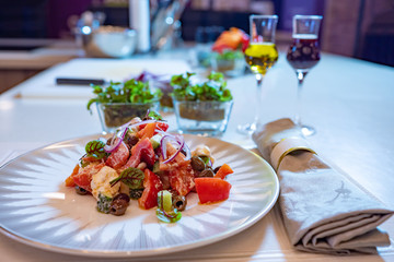 Table setting. The table is set for one person. Vegetable dish on a plate. Cutlery, food and drinks on a white tablecloth. Snack. Vegetable salad.