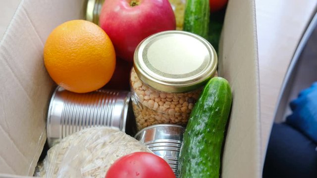 Courier or volunteer hands put food in a box for delivery to the customer