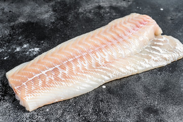 Raw Norwegian skrei cod fish fillet. Black background. Top view