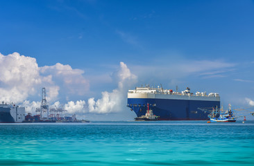 Automobile Transporter underway at sea by Tugboat assistance. Logistics and transportation of...