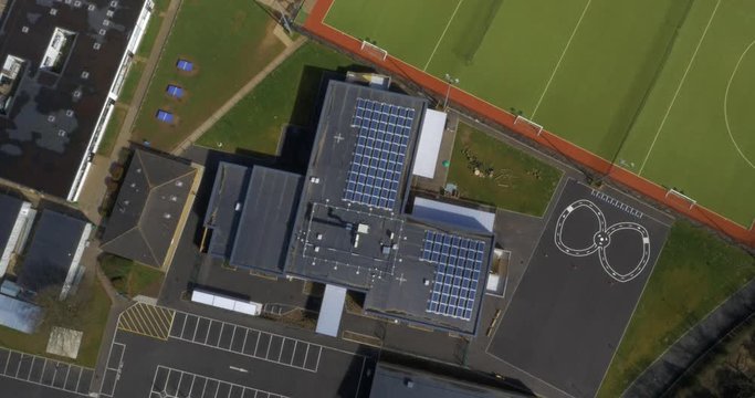 School with solar panels and playground area in sunshine, England, UK