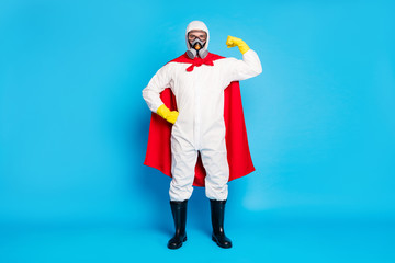 Full length photo strong doctor man show muscles power stop biological danger covid epidemic spread wear yellow latex gloves goggles white suit red mantle isolated blue color background