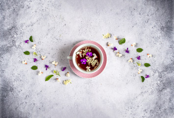 Feminine pink tea cup and fresh spring floral tea top view.