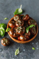 Fresh tomatoes in a plate on a dark background. Harvesting tomatoes.