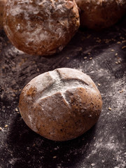the rustic loaves of bread placed on wooden black background