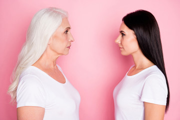 Profile photo of pretty old mother young daughter two ladies standing opposite look eyes see age difference wisdom wear casual white t-shirts isolated pastel pink color background