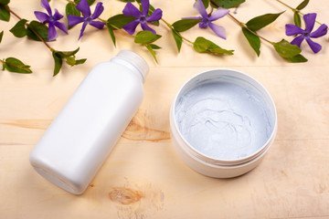 skin cream with purple flowers on a yellow background. beauty female skin care