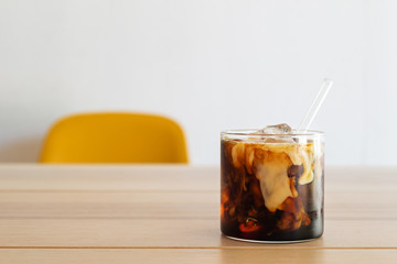 cold brew coffee with milk on white wooden table.