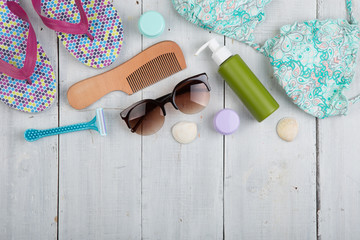 Travel concept - flip flops, swimsuit, sunglasses and sunblock, packaging for beach vacation