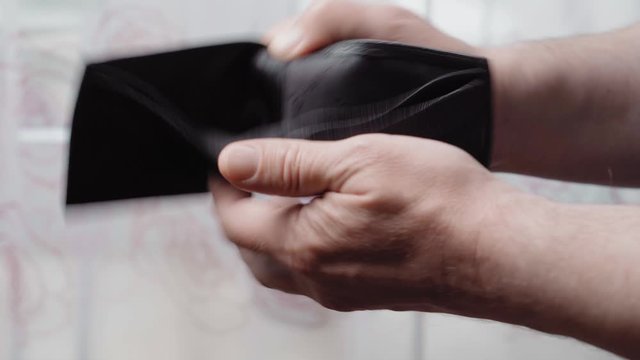 Empty leather wallet in the hands of a man, close-up. Poverty concept