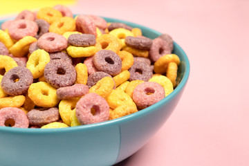 Breakfast with Colorful cereals in blue bowl and pink background