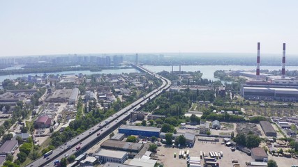 panorama with river and pipe factory on top shot of a modern industrial motor vehicle interchange with overpasses and bridges. part on reconstruction with speed limits to a minimum. aerial view 