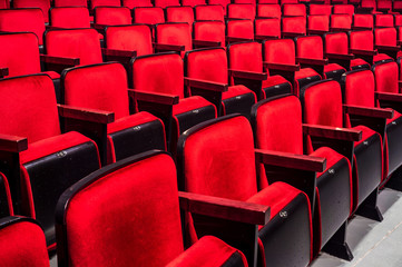 Rows of empty red seats in a theater