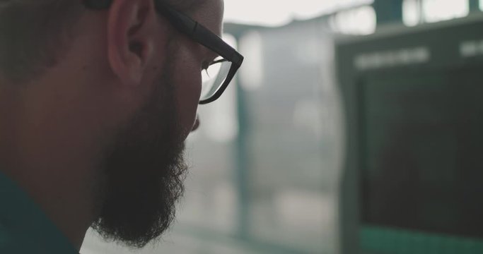 Close view of engineer in glasses works with contol panel