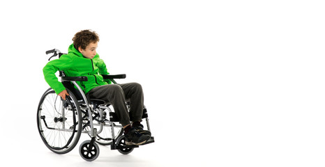 Obraz na płótnie Canvas Little boy in wheelchair on white background , boy is sitting in a wheelchair on a white background. Hospital patient with disability