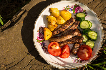 grilled meat with vegetables on a wooden table
