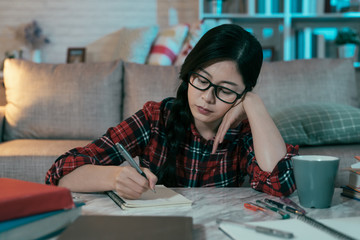 portrait of asian woman with attentive look is keeping diary. daily routine concept japanese female...