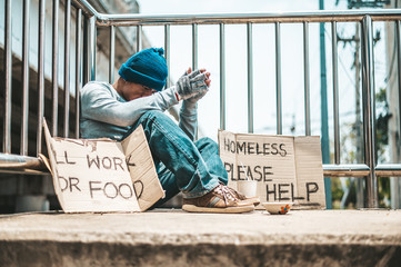 The man sitting begging on an overpass.
