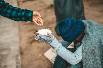 Beggars wrapped in cloth and then put on a hat and sat down beside the street and someone gave...