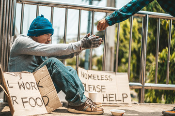 The man sitting begging on an overpass.