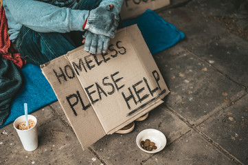The beggars sat beside the street with a homeless message. Please help and work with food.