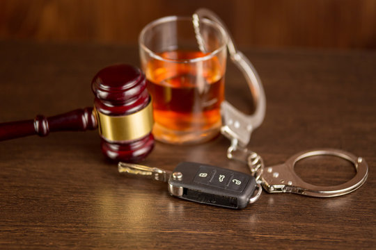 Car keys and glass of alcohol on table in pub or restaurant.