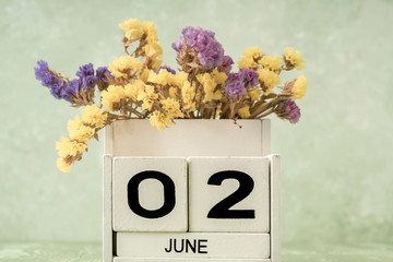 White cube calendar for june on green background with copy space