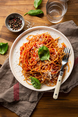 Whole wheat spaghetti  with tomato sauce on wooden table