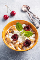 Grain curd muesli with fresh cherries on a plate. Concept healthy Breakfast with cottage cheese and berries. Copy space