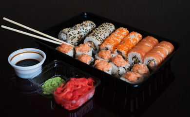 Set with an assortment of fresh Japanese rolls with fish. Roll with rice and sesjut. Japanese rolls on black background