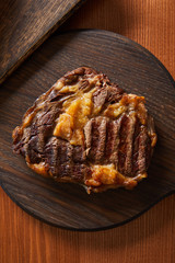 top view of tasty grilled steak served on wooden board