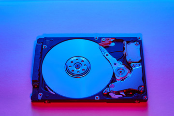 Disassembled hard drive from the computer, hdd with neon light. Opened hard drive Part of computer...