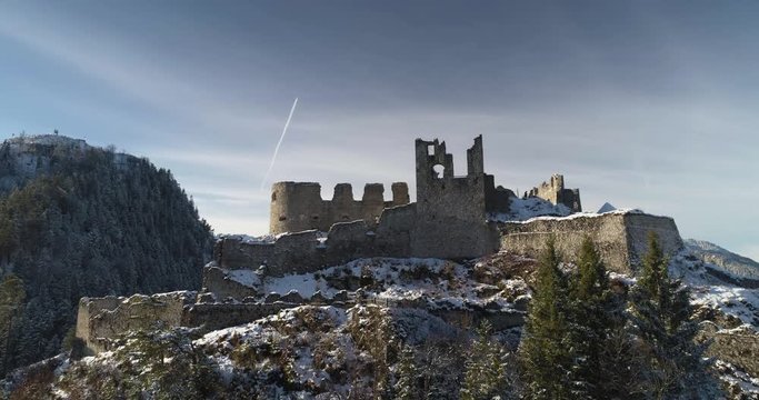 Aerial rising up shot reveals huge Austrian mountain range behind Ehrenberg Castle