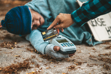 Beggars sitting under the overpass with a credit card and credit card swipe machine