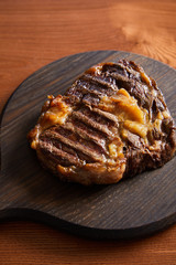 tasty grilled steak served on wooden board
