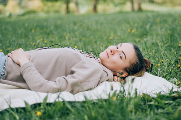 beautiful girl relaxing lying on the grass in the garden