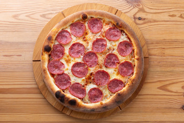 hearty italian pizza on a wooden board. cheese pizza with salami sausage