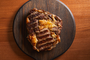 top view of tasty grilled steak served on wooden board