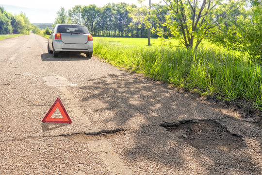 The sign of an emergency stop due to the puncture of the wheel. Potholes on the road. Terrible highway condition.