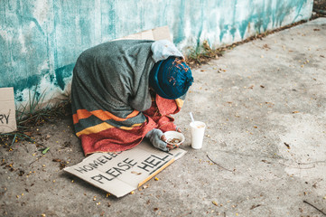 Beggars sitting on the street with homeless messages please help.